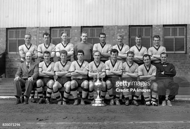Wolverhampton Wanderers who retained their Football League First Division Championship with 61 points from 42 games. Pictured with the trophy are....