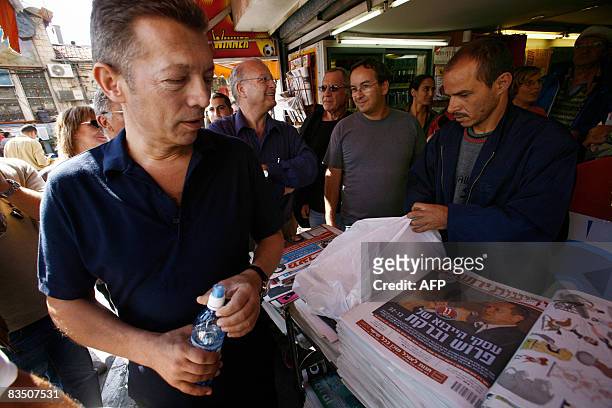 Israeli-Russian billionaire Arkady Gaydamak looks down at a newspaper portraying candidates for the mayoral election while on a campaign tour at the...
