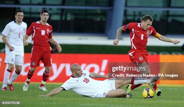Wales' Craig Bellamy is tacked by Poland's Mariusz Lewandowski during the International Friendly at the Vila Real De Santo Antonio Sports Complex,...