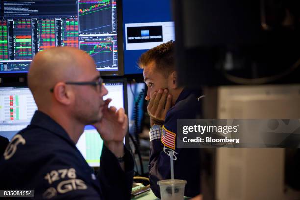 Traders work on the floor of the New York Stock Exchange in New York, U.S., on Friday, Aug. 18, 2017. Stocks were mixed and the S&P 500 Index turned...