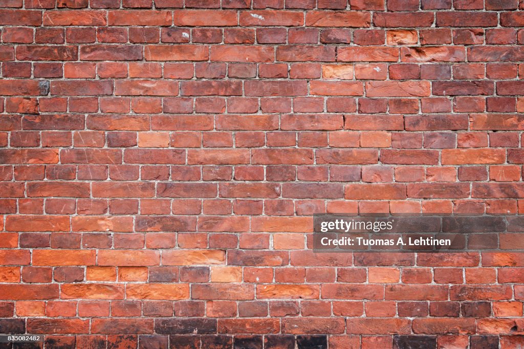 Old and aged red brick wall texture background with vignetting.