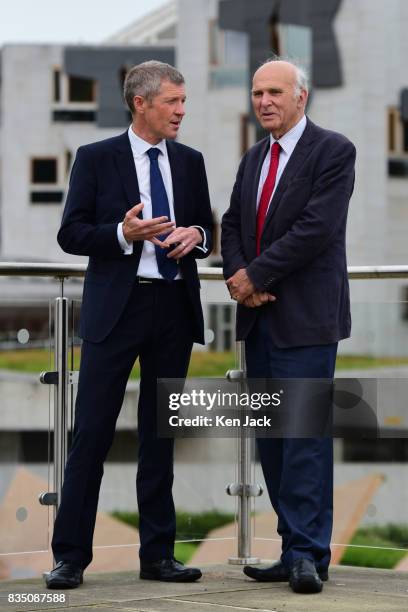 Liberal Democrat leader Vince Cable and Scottish party leader Willie Rennie pose for photographs with the Scottish Parliament in the background ahead...