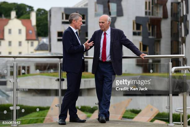 Liberal Democrat leader Vince Cable and Scottish party leader Willie Rennie pose for photographs with the Scottish Parliament in the background ahead...