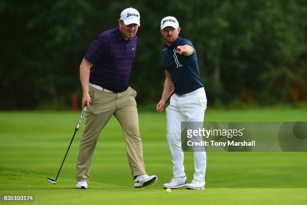 Graeme Brown of Montrose Golf Links Ltd points out the line of a putt to Gareth Wright of West Linton Golf Club on the 18th green during the...