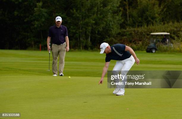 Graeme Brown of Montrose Golf Links Ltd points out the line of a putt to Gareth Wright of West Linton Golf Club on the 18th green during the...