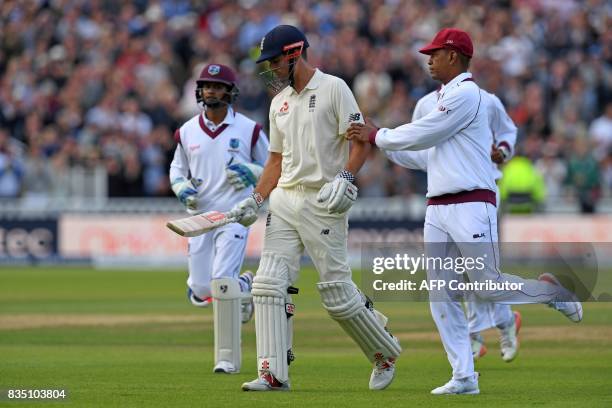 West Indies players run to shake hands with England's Alastair Cook as he leaves the field after losing his wicket for 243 during play on day 2 of...