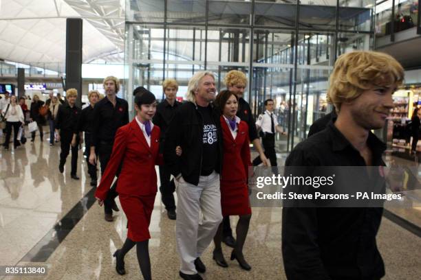 Sir Richard Branson walks to a press conference at Hong Kong Airport after briefly stopping there en-route to Sydney on his around the world in eight...