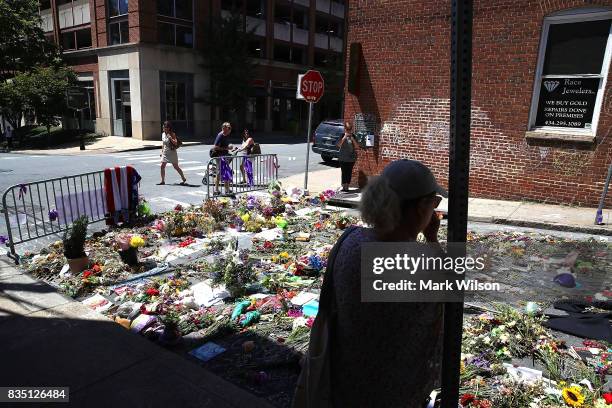 Flowers lay on the street where Heather Heyer was killed and 19 others injured when a car slammed into a crowd of people protesting against a white...