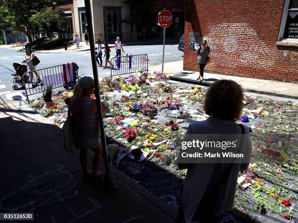 Flowers lay on the street where Heather Heyer was killed and 19 others injured when a car slammed into a crowd of people protesting against a white...