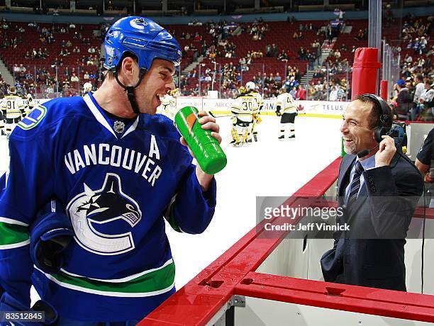 Willie Mitchell *8 of the Vancouver Canucks laughs with TSN announcer Ray Ferraro during the game against the Boston Bruins at General Motors Place...
