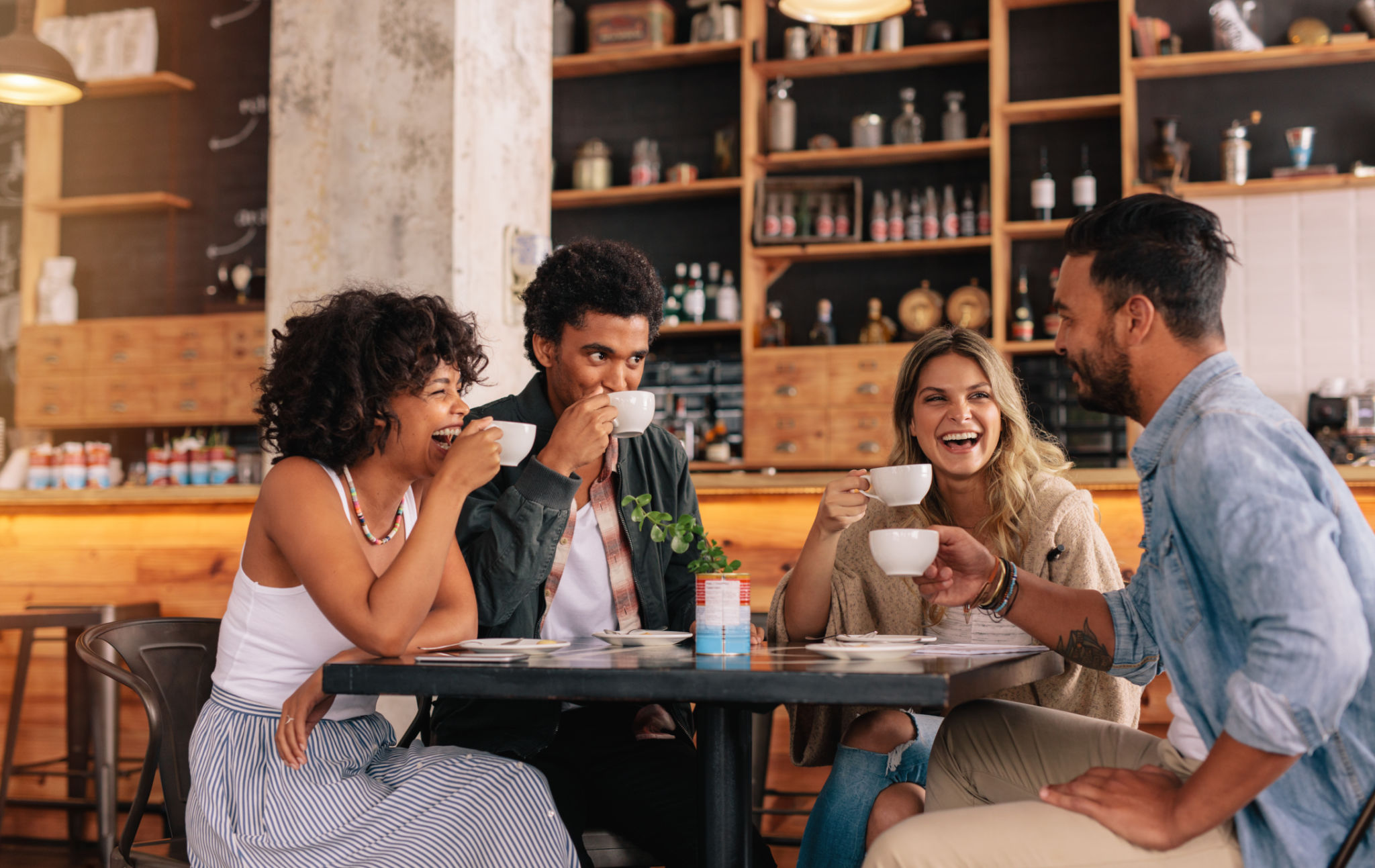 Diverse group of friends enjoying herbal tea from Indigitea together Diverse group of friends enjoying herbal tea from Indigitea together