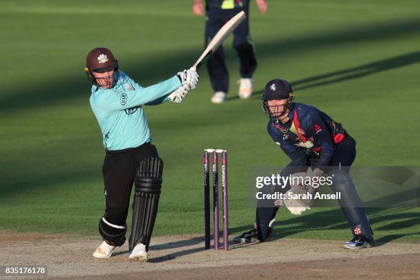 Jason Roy of Surrey hits a boundary as Kent Spitfires wicket keeper Sam Billings looks on during the NatWest T20 Blast South Group match between Kent...