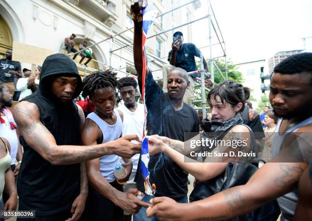 Demonstrators burn a Confederate flag replica in reaction to a potential white supremacists rally on August 18, 2017 in Durham, North Carolina. The...