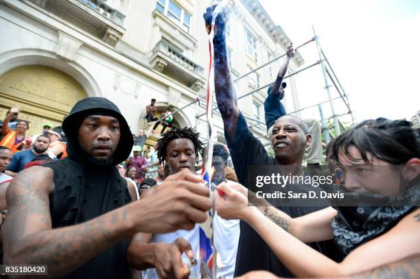 Demonstrators burn a Confederate flag replica in reaction to a potential white supremacists rally on August 18, 2017 in Durham, North Carolina. The...