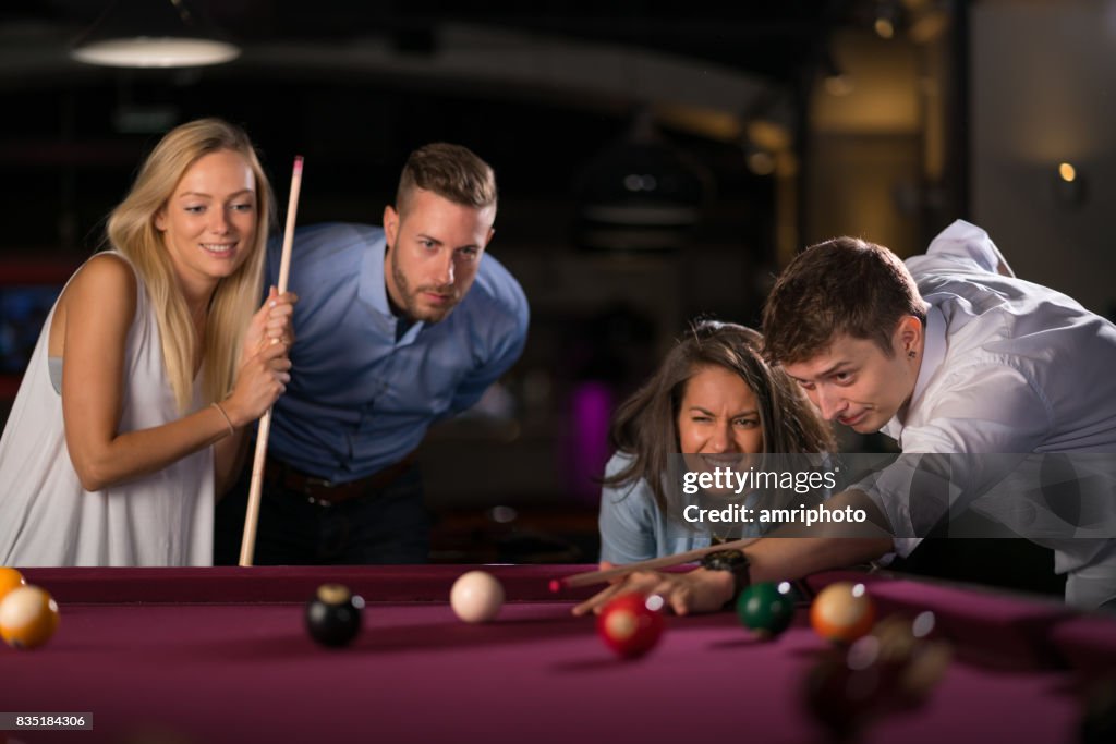 Young people playing pool in pub