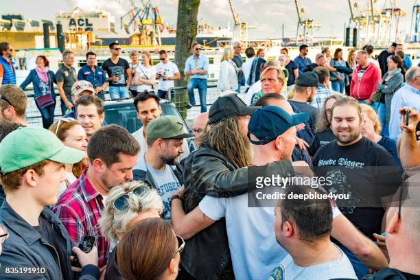 a man takes a photo of magnus walker and his fans on the fischmarkt hamburg - fischmarkt hamburg stock pictures, royalty-free photos & images
