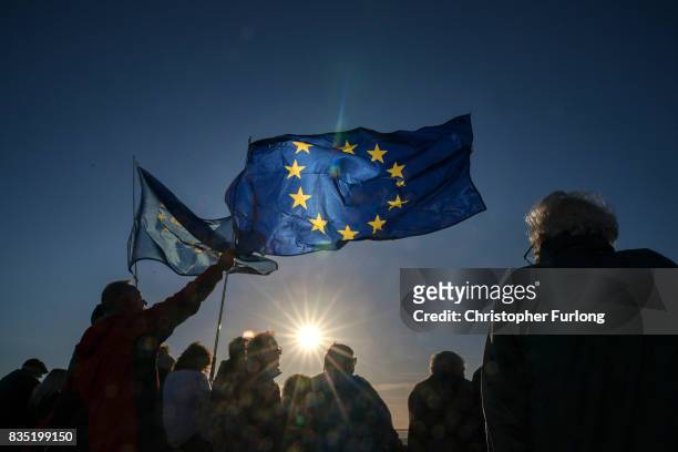 Supporters wave EU flags as they listen to Labour Party Leader Jeremy Corbyn during a rally on Southport Beach on August 18, 2017 in Southport,...