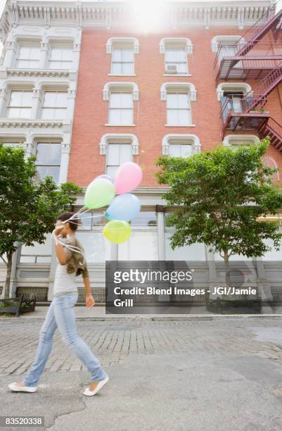 african woman walking with bunch of balloons - helium stock pictures, royalty-free photos & images