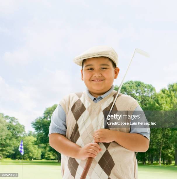 hispanic boy playing golf - golf argyle stock pictures, royalty-free photos & images