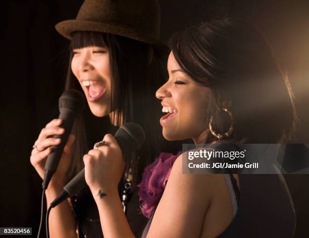 multi-ethnic friends singing karaoke - duet stock pictures, royalty-free photos & images