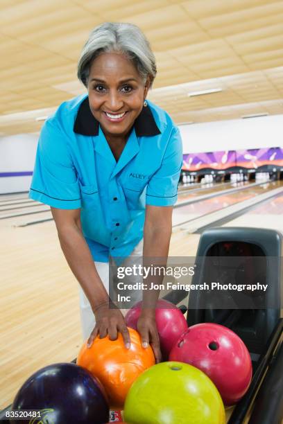 african woman choosing bowling ball - bowling woman stock-fotos und bilder