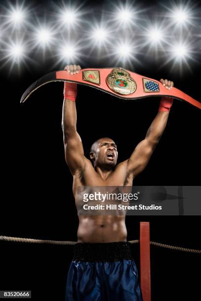 african boxer lifting championship belt - championship ring foto e immagini stock