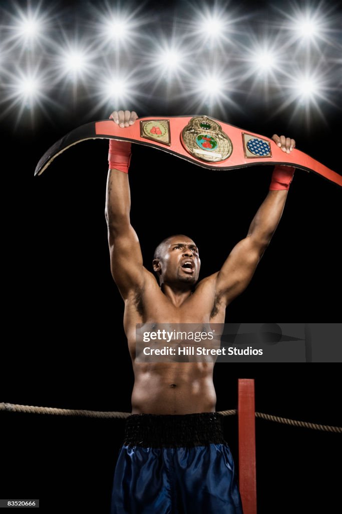 African boxer lifting championship belt