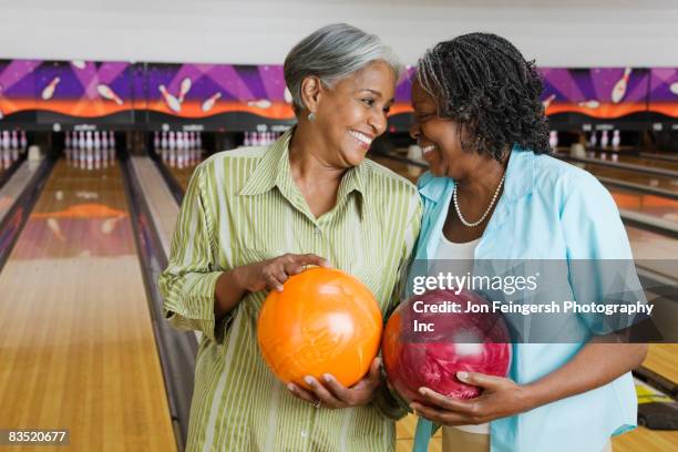 african women holding bowling balls in bowling alley - bowling woman stock pictures, royalty-free photos & images