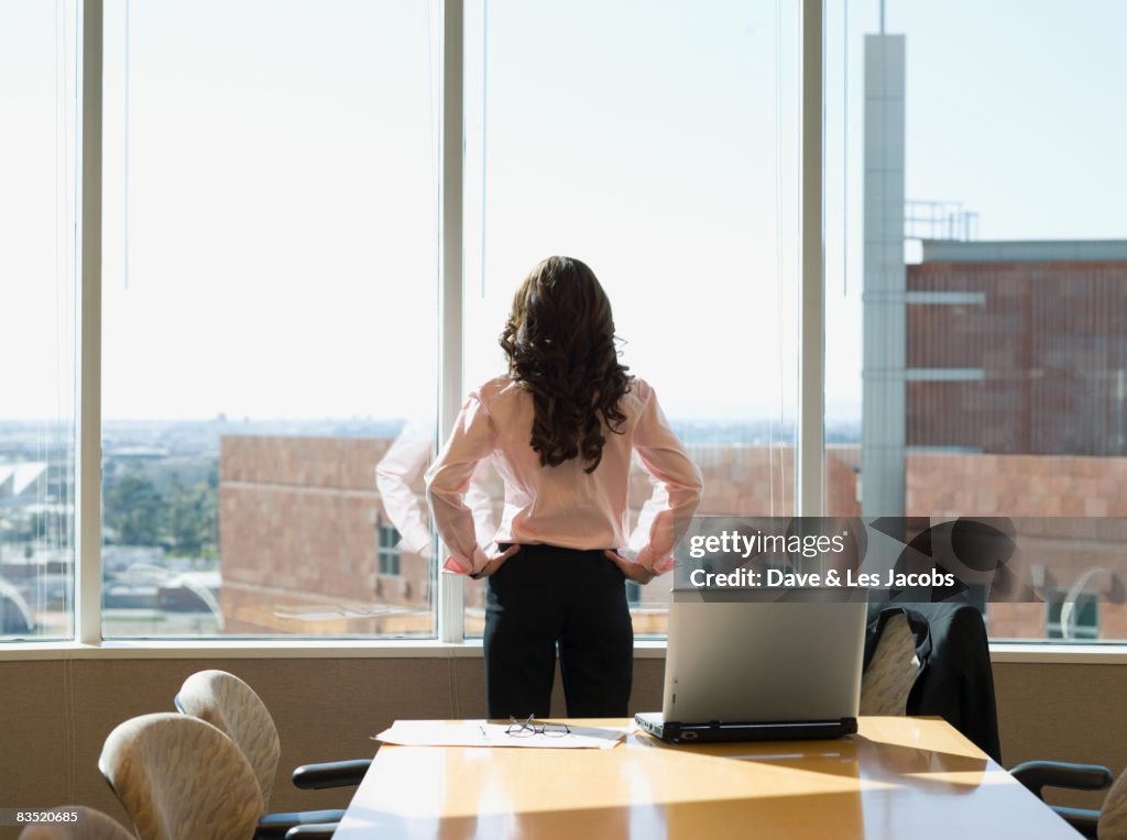 Mixed race businesswoman standing in conference room