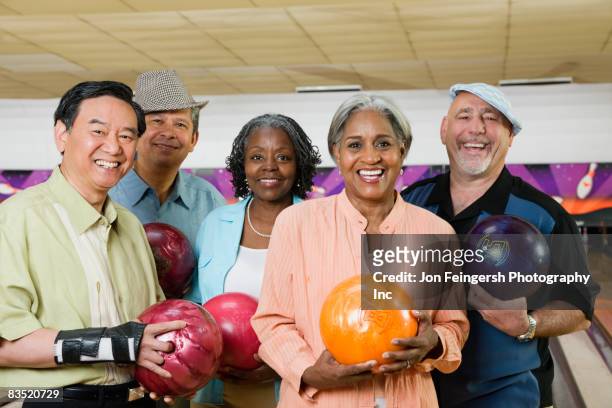 friends holding bowling balls in bowling alley - e league fotografías e imágenes de stock