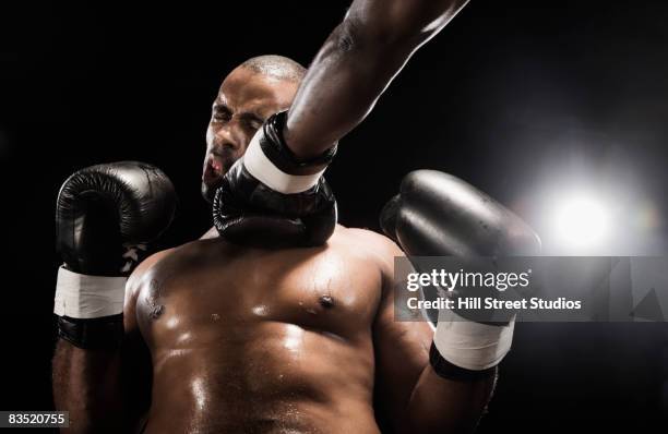 african boxer hitting opponent - boxing glove coloured background stock pictures, royalty-free photos & images