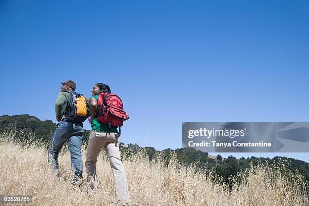 multi-ethnic couple backpacking in rural area - fairfax stock pictures, royalty-free photos & images