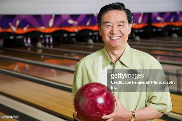 asian man in bowling alley - man holding bowling ball stock pictures, royalty-free photos & images