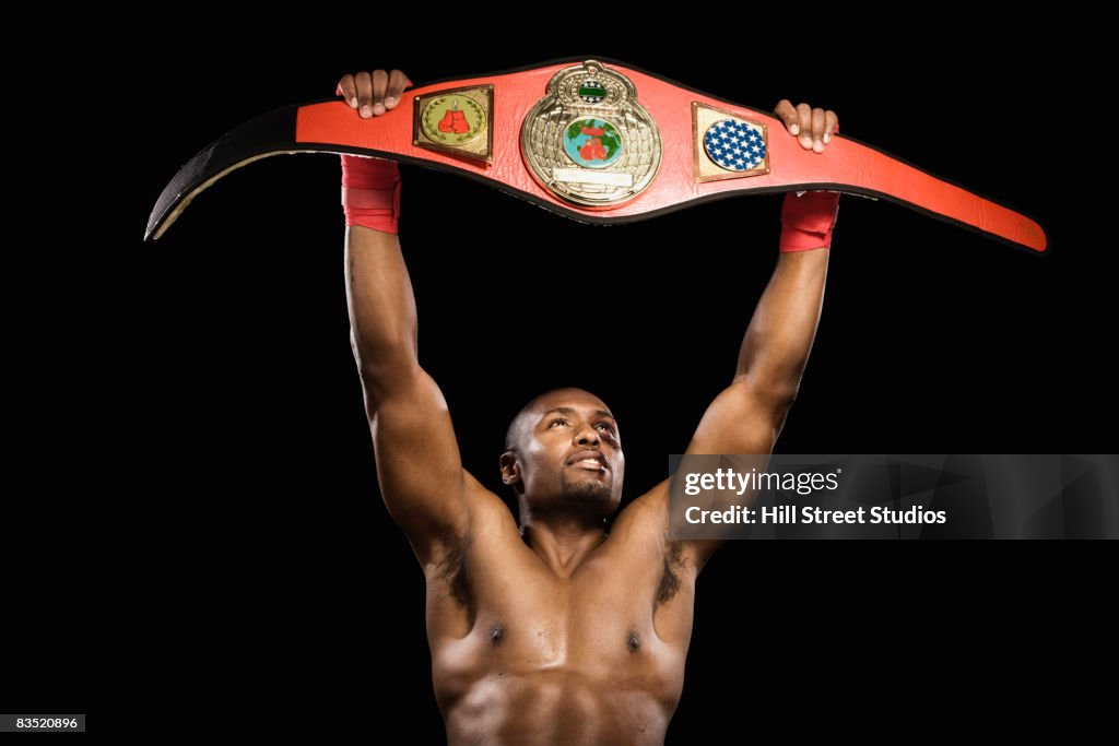 African boxer lifting championship belt