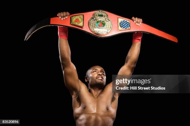 african boxer lifting championship belt - belt stock-fotos und bilder