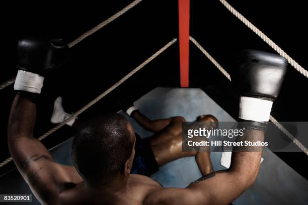 african boxer standing over knocked out opponent - mettre knock out photos et images de collection