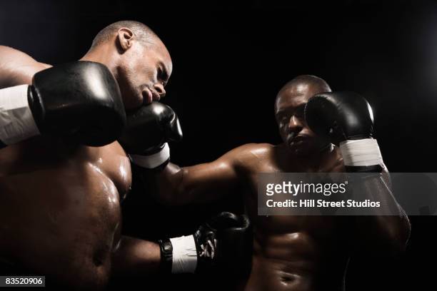 african boxer hitting opponent - championship ring stockfoto's en -beelden
