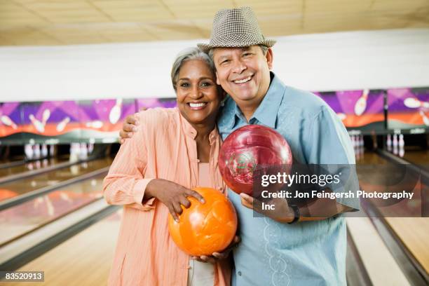 multi-ethnic friends holding bowling balls in bowling alley - man holding bowling ball stock pictures, royalty-free photos & images