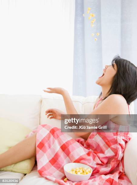 asian woman tossing popcorn into her mouth - catching food stock pictures, royalty-free photos & images