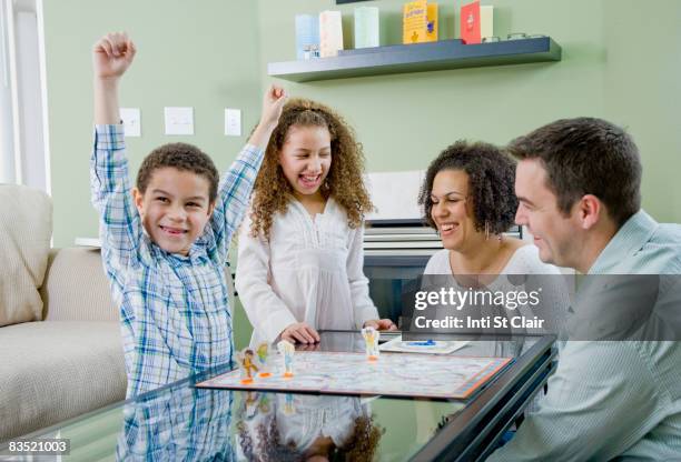 mixed race family playing board game - game night leisure activity foto e immagini stock