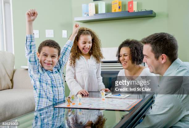 mixed race family playing board game - 4 people playing games stock pictures, royalty-free photos & images