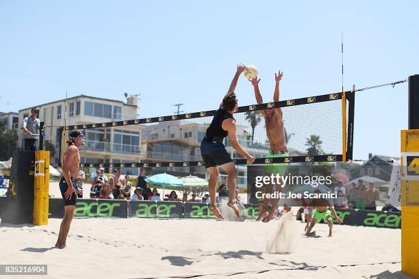 Avery Drost and John Mayer jump for the ball at the net during their round 2 match at the AVP Manhattan Beach Open - Day 2 on August 18, 2017 in...