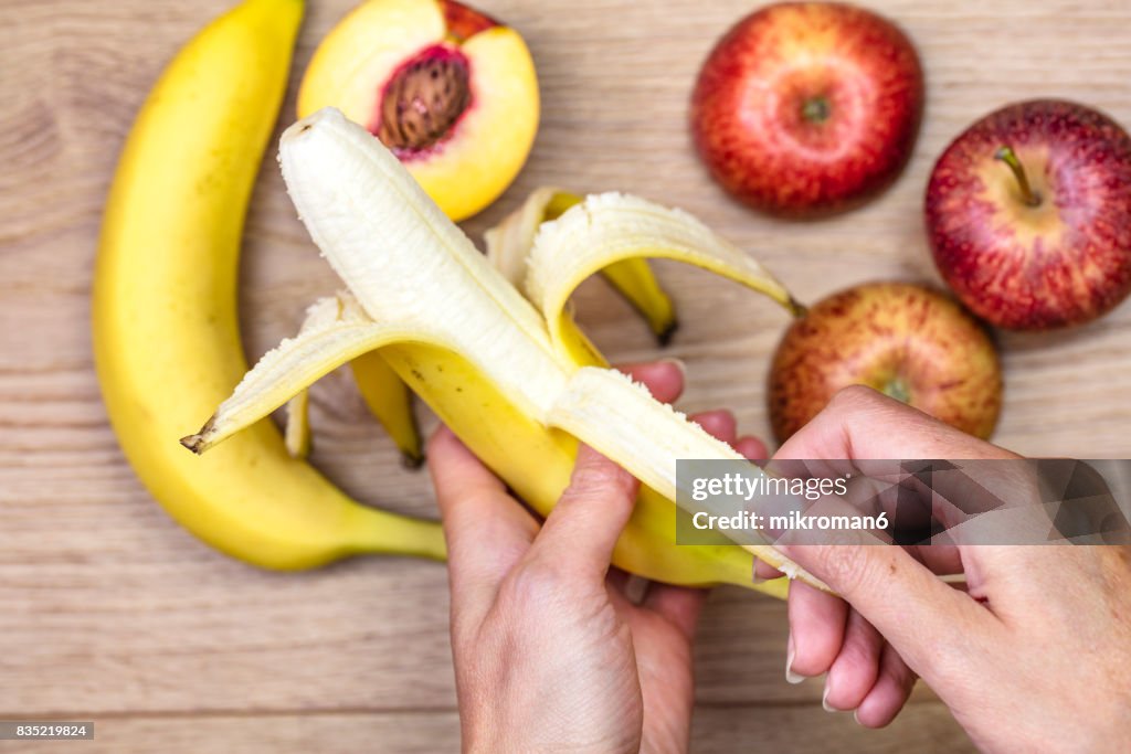 Woman peeling off banana  for healthy eating.
