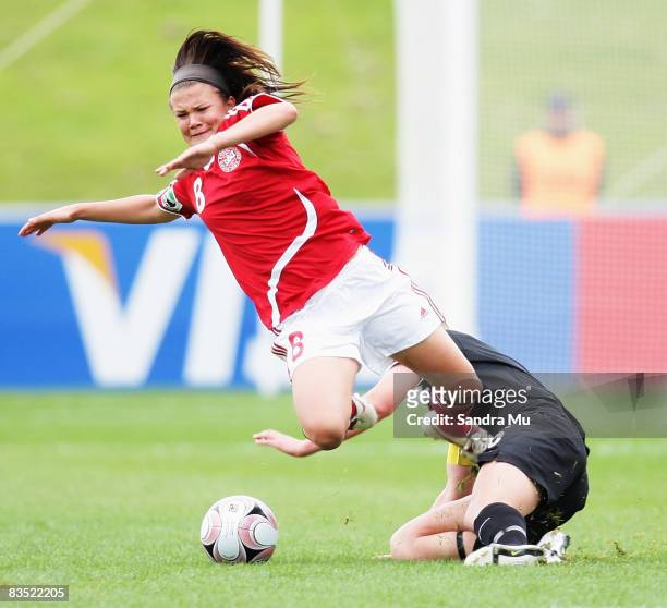 Briony Fisher of New Zealand trips up Katrine Veje of Denmark during the FIFA U-17 Women's World Cup match between New Zealand and Denmark at North...