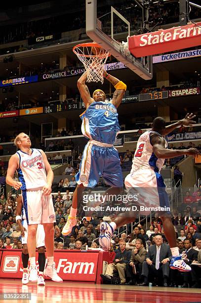 Kenyon Martin of the Denver Nuggets goes up for a dunk between Chris Kaman and Tim Thomas of the Los Angeles Clippers at Staples Center on October...
