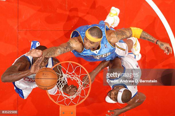 Kenyon Martin of the Denver Nuggets goes up for a shot against Tim Thomas and Baron Davis of the Los Angeles Clippers at Staples Center on October...