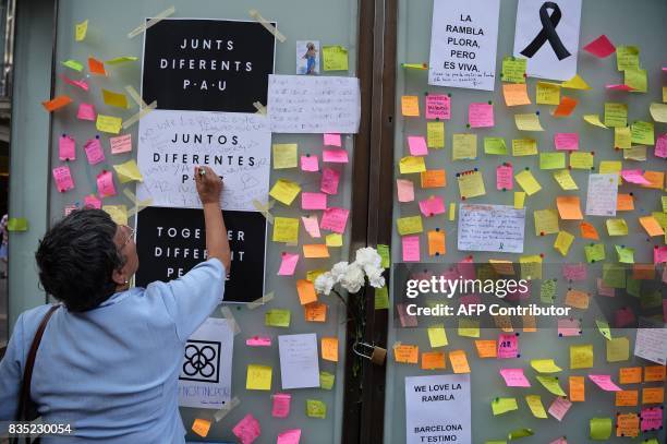 Woman writes a message against the attacks and for the victims of the attack in Barcelona on Las Ramblas boulevard in Barcelona as people pay tribute...