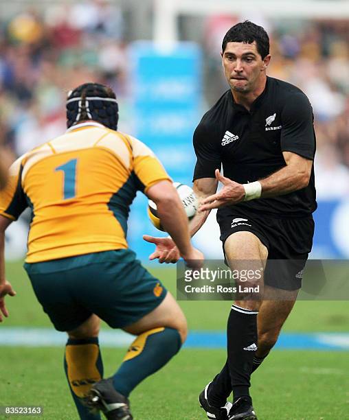 Stephen Donald of the All Blacks passes the ball around Benn Robinson during the Bledisloe Cup match between the Australian Wallabies and the New...