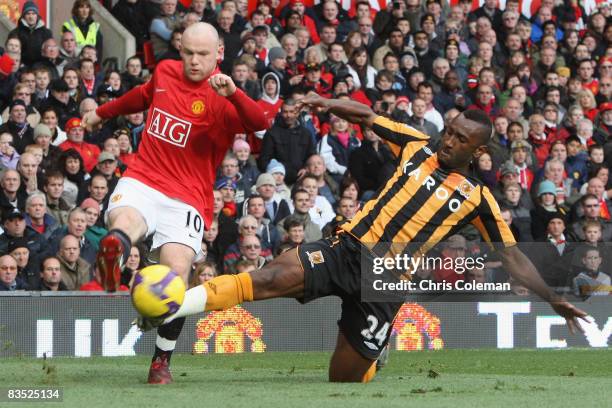 Wayne Rooney of Manchester United clashes with Kamil Zayatte of Hull City during the Barclays Premier League match between Manchester United and Hull...