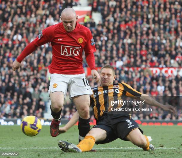 Wayne Rooney of Manchester United clashes with Andy Dawson of Hull City during the Barclays Premier League match between Manchester United and Hull...